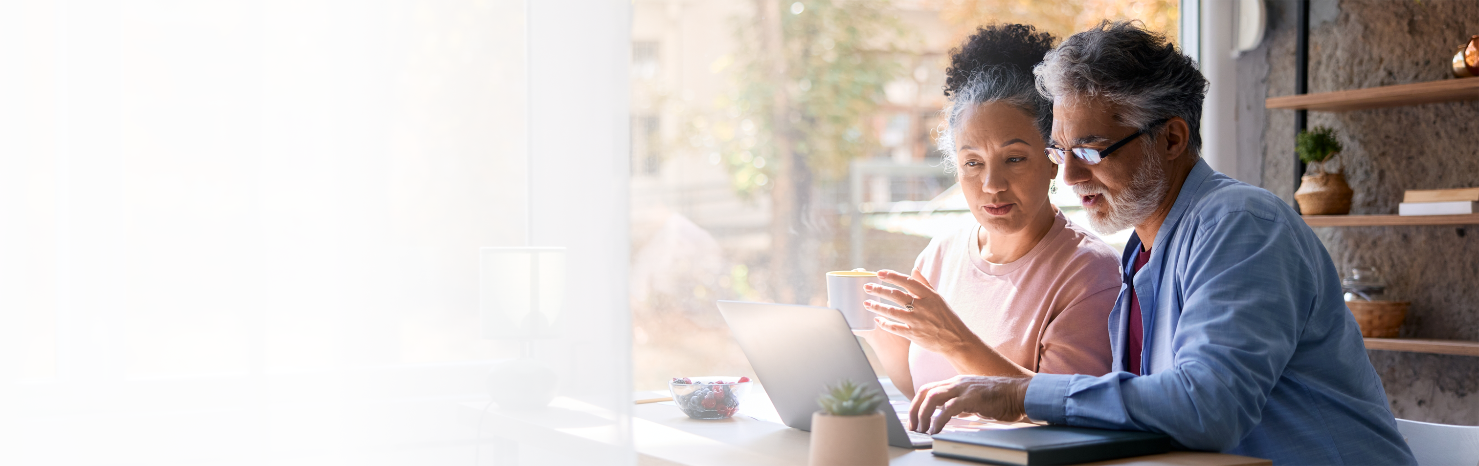 Man and woman looking at laptop on table at home